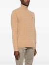 Maglione in lana beige intrecciata a collo alto